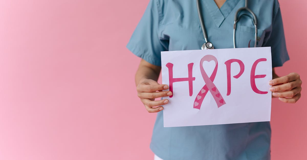 Doctor holding a 'Hope' sign advocating breast cancer awareness with a pink background.